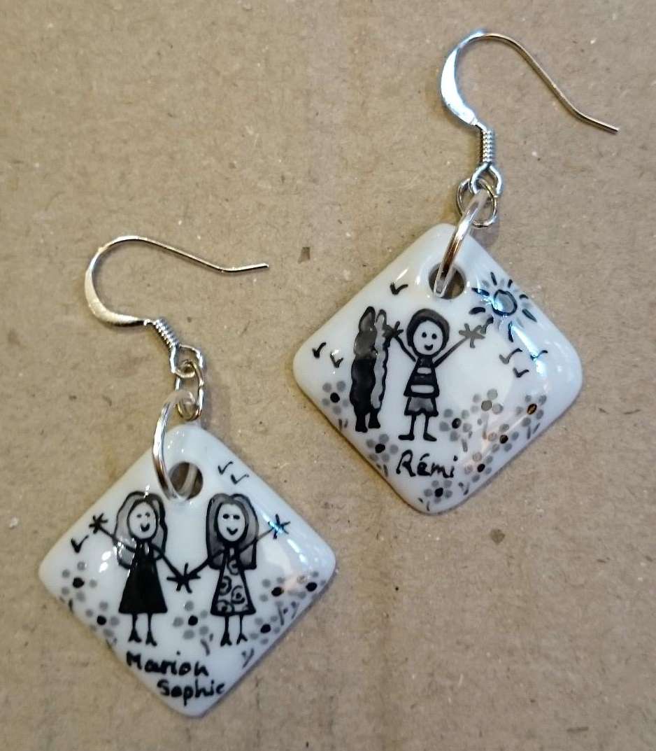 Boucles d'oreilles carrées en porcelaine personnalisées dans un style naïf en noir et gris par des enfants.